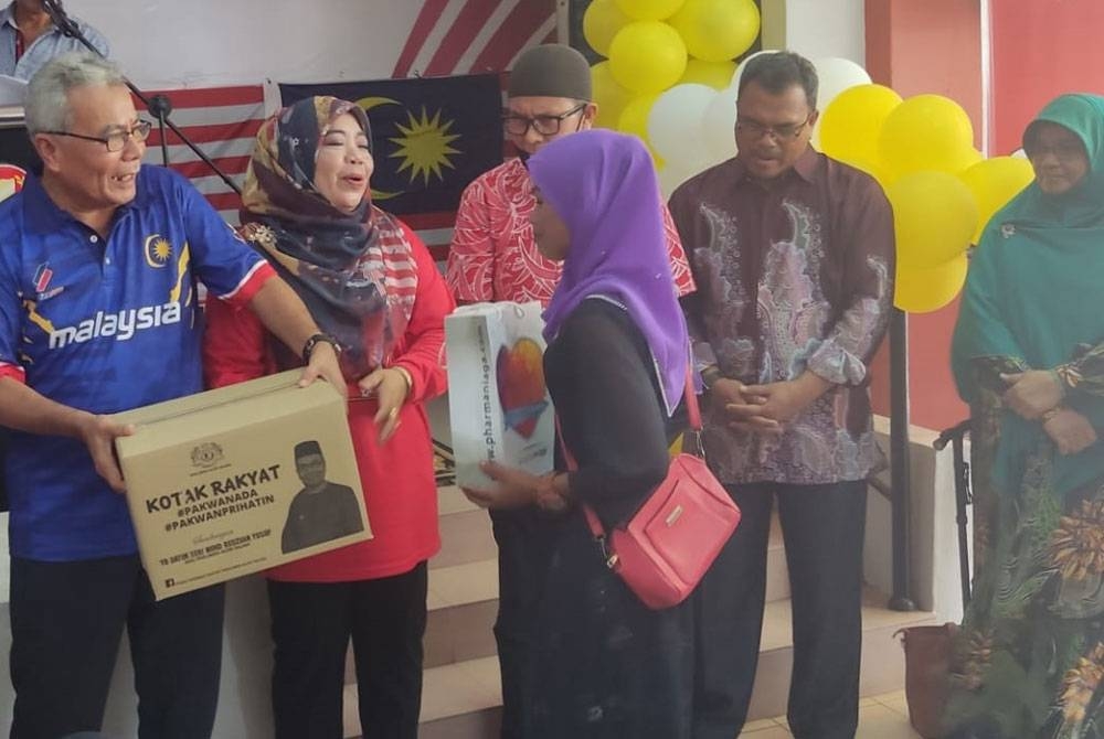 Mohd Redzuan (kiri) dan Exco Kedah, Datuk Halimaton Shaadiah Saad (dua kiri) menyerahkan sumbangan sempena Program Semarak Merdeka 65 sempena Sambutan Hari Kebangsaan ke-65 di Napoh pada Khamis.