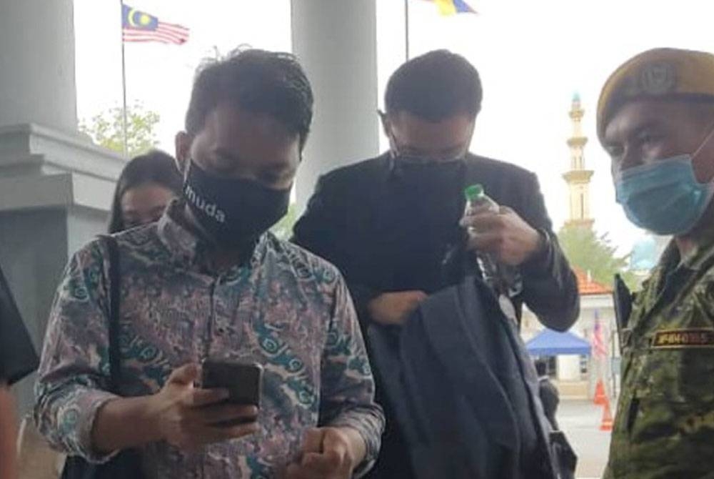 Setiausaha Agung Ikatan Demokratik Malaysia (Muda), Amir Hariri Abd Hadi (dua dari kiri) hadir di Mahkamah Majistret Kuala Lumpur berhubung kes perhimpunan isu projek kapal tempur pesisir (LCS) pada Jumaat.