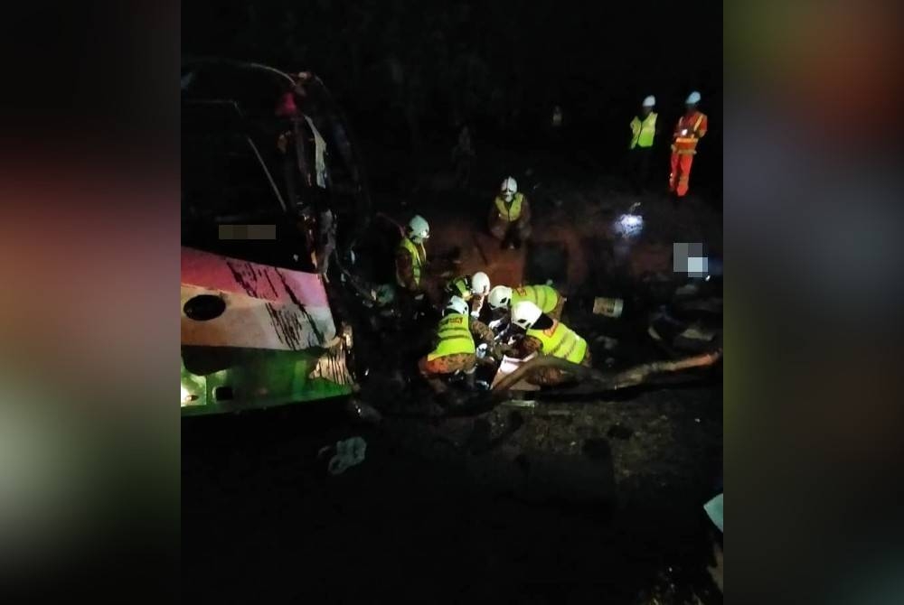 Anggota bomba membantu mengeluarkan mayat pemandu lori yang tersepit dalam kemalangan di KM116 Lebuh Raya Utara Selatan menghala utara, awal pagi Sabtu. - Foto Bomba