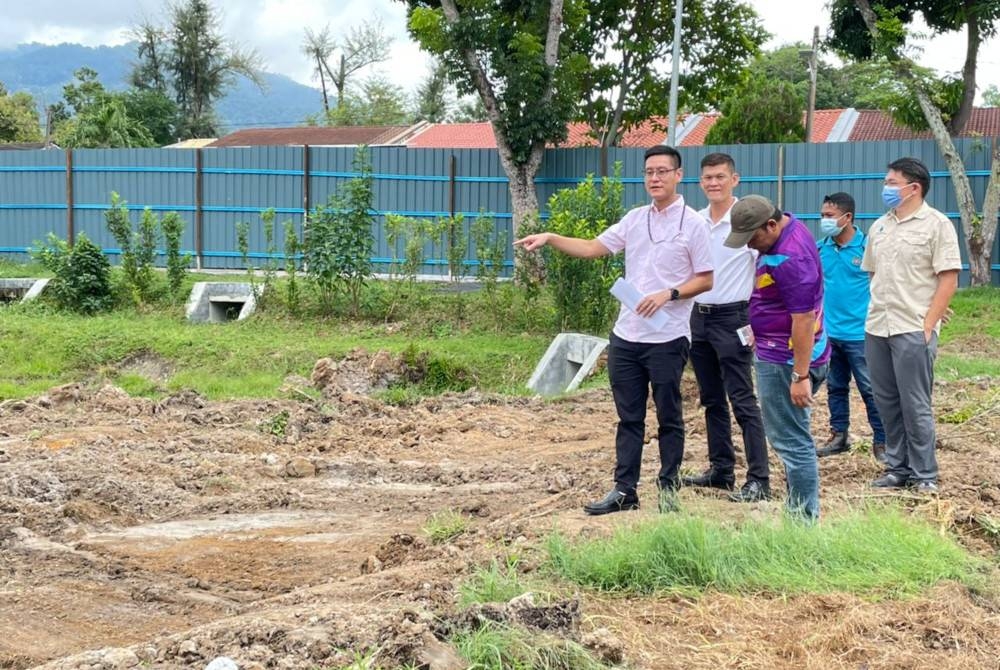 Zairil (kiri) menunjukkan kerja-kerja yang dijalankan untuk membina Projek Tebatan Banjir Van Praagh di Jelutong pada Ahad.