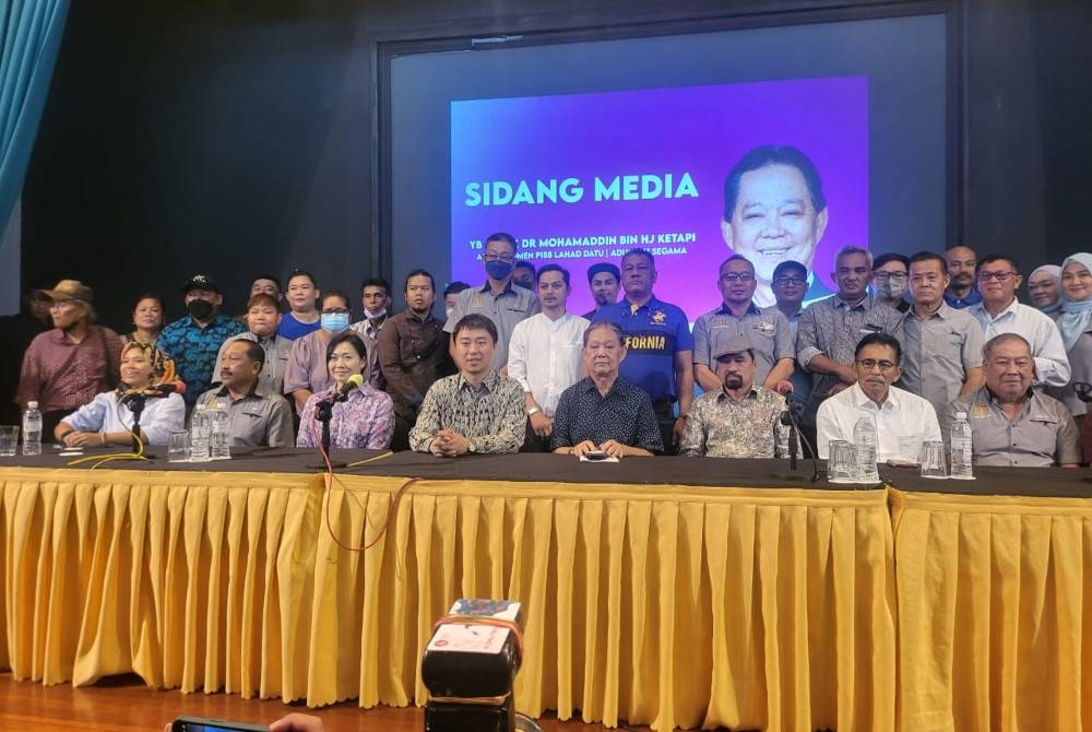 Larry (duduk, empat dari kiri) bersama Mohamaddin (lima dari kiri) dan Kamarazaman (empat dari kanan) pada sidang akhbar di Kota Kinabalu pada Ahad.	