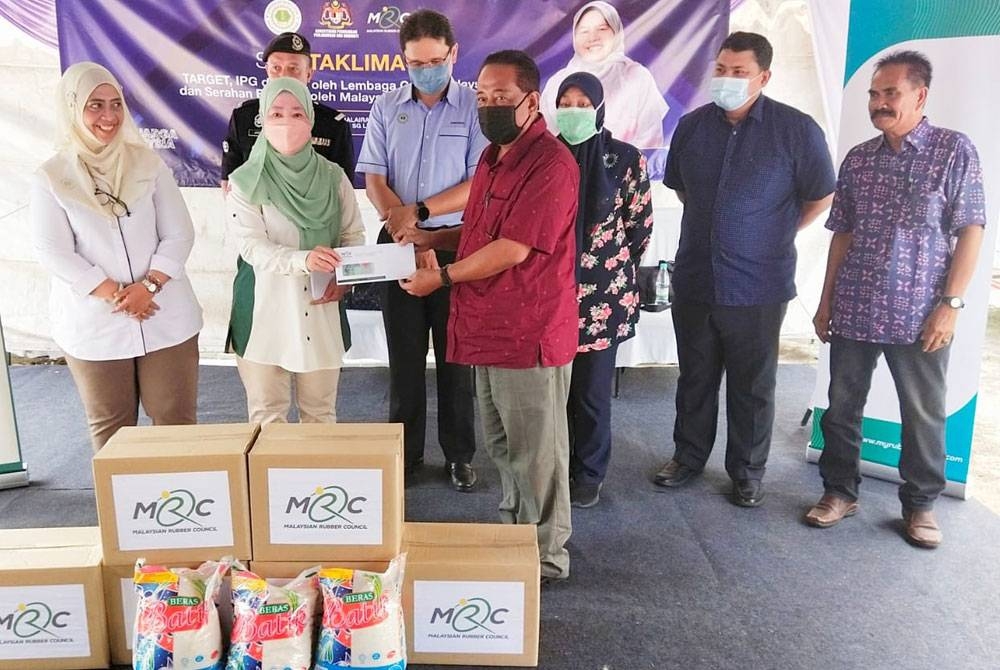 Dr Zairossani (belakang, tiga dari kiri) menyaksikan penyerahan bantuan MRC kepada pekebun kecil yang disampaikan Dr Daroyah sempena Program Taklimat Target di balai raya Kampung Kuin 1, Sungai Lembing di sini pada Ahad.