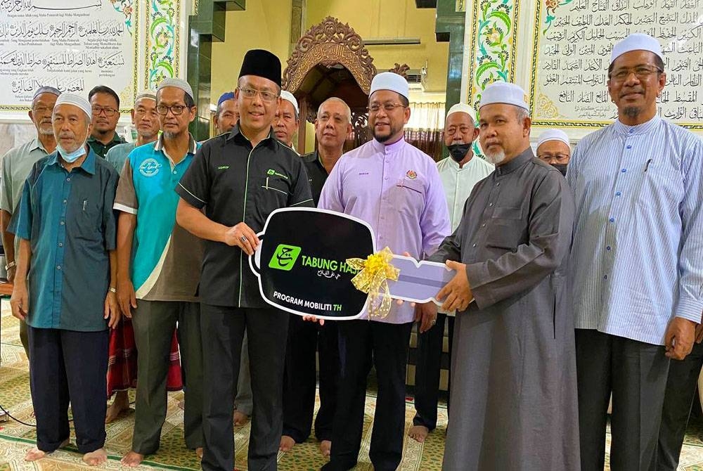 Ahmad Marzuk (tiga dari kanan) semasa menyampaikan replika kunci van jenazah dan sumbangan Musaadah Bencana di Masjid Mukim Ar-Rahman Kampung Repek, Bachok pada Ahad.