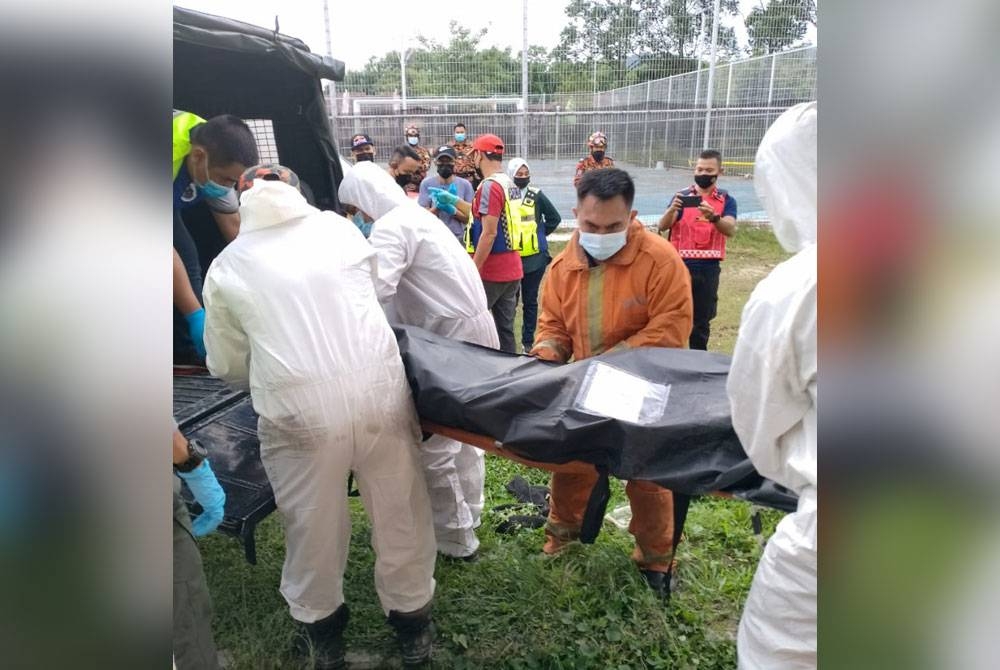 Anggota bomba dan penyelamat mengusung mayat seorang remaja ditemui dalam sebuah tandas awam yang terbakar di Puncak Alam, Sungai Buloh pada Ahad.