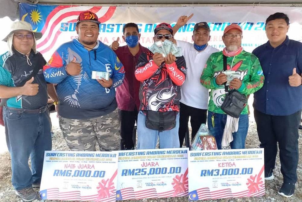 Shamsudin (tiga dari kanan) bersama tiga pemenang utama pertandingan memancing Surfcasting Ambang Merdeka di Pantai Tambak Klebang, di sini pada Ahad.