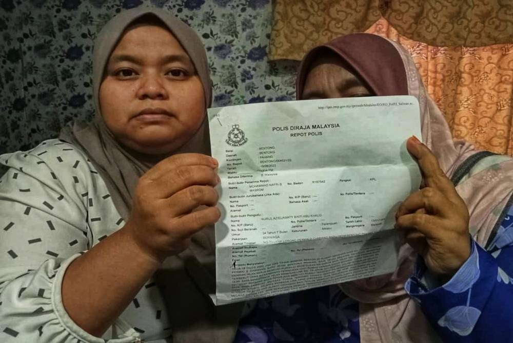 Nurul Azilawati (kiri) dan ibunya,Habsah menunjukkan laporan polis yang dibuat mereka selepas mendakwa kehilangan duit dari akaun bank hampir RM12,000