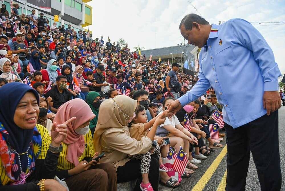 Aminuddin (kanan) berkesempatan beramah mesra dengan pengunjung pada sambutan Hari Kebangsaan ke-65 peringkat negeri pada Rabu.