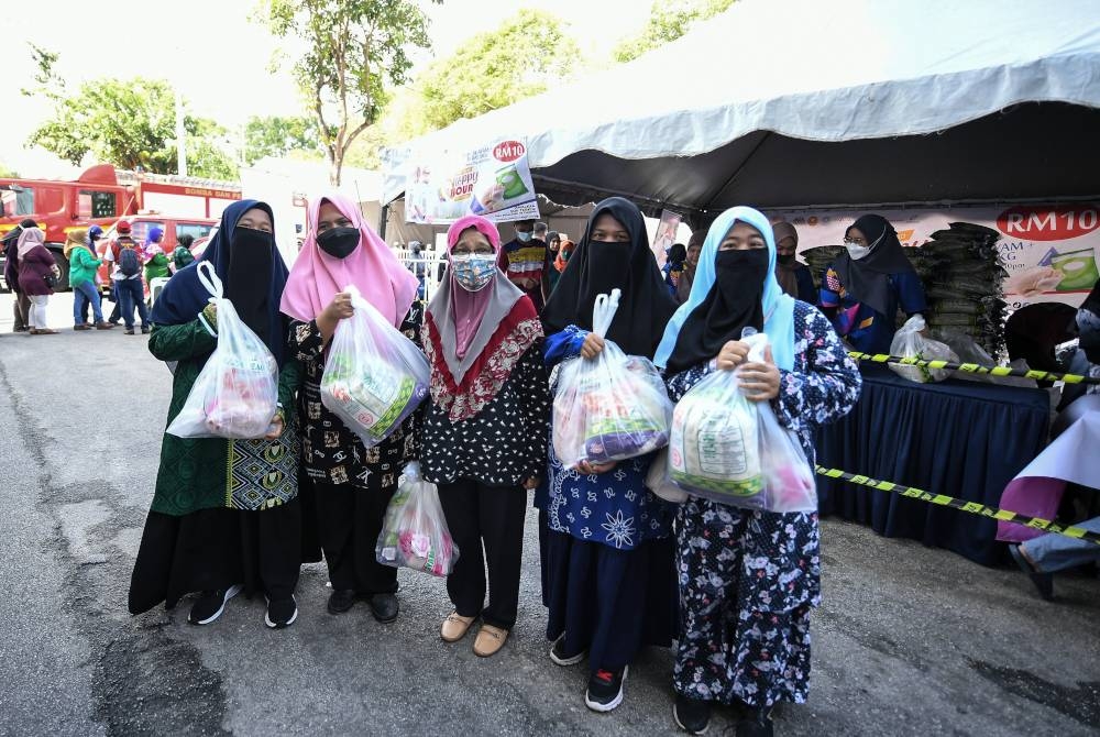 Pengunjung Mardziyah Ishak, 41, bersama keluarganya tidak melepaskan peluang untuk membeli jualan Happy Hour yang bermula 11 pagi sempena program Jelajah Aspirasi Keluarga Malaysia di pekarangan Stadium Darul Aman, Alor Setar, pada Jumaat. - Foto Bernama