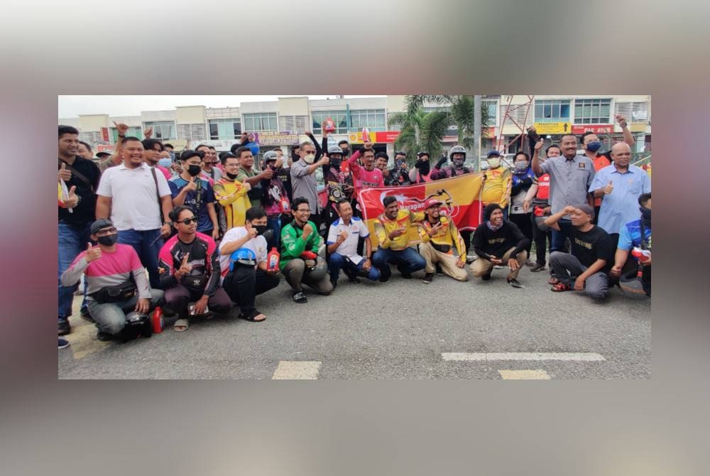 Dzulkefly bergambar bersama penghantar makanan pada Kempen Keselamatan Motosikal P-Hailing di Bandar Puncak Alam, Kuala Selangor pada Jumaat.