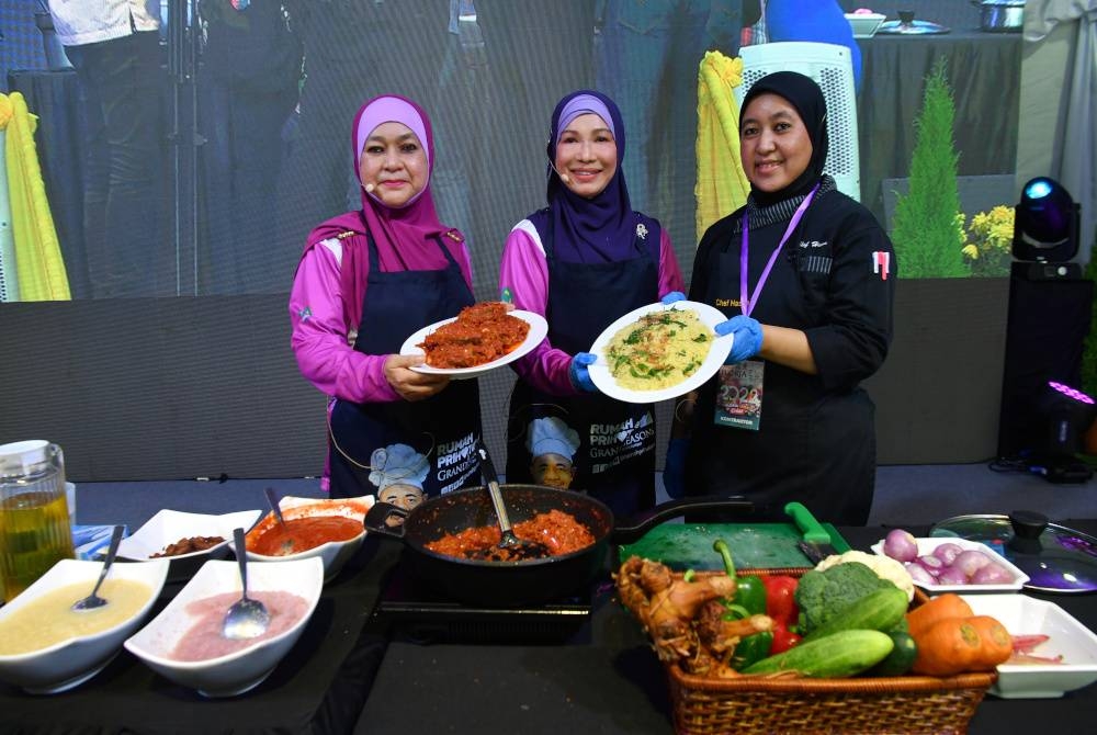 Muhaini (tengah) menunjukkan ikan senangin sambal bunga kantan dan nasi minyak teh bunga ketika Program Memasak Citarasa Floria bersama Isteri Perdana Menteri sempena Floria DiRaja Putrajaya 2022 di Anjung Floria, pada Jumaat. - Foto Bernama