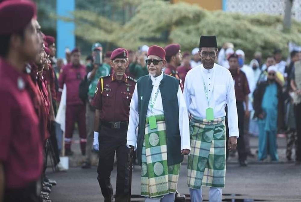 Abdul Hadi (tengah) ketika memeriksa perbarisan Jabatan Amal Malaysia sebelum perasmian Muktamar Tahunan Pas Pusat ke-68 di Kompleks Pas Kota Sarang Semut pada Sabtu.