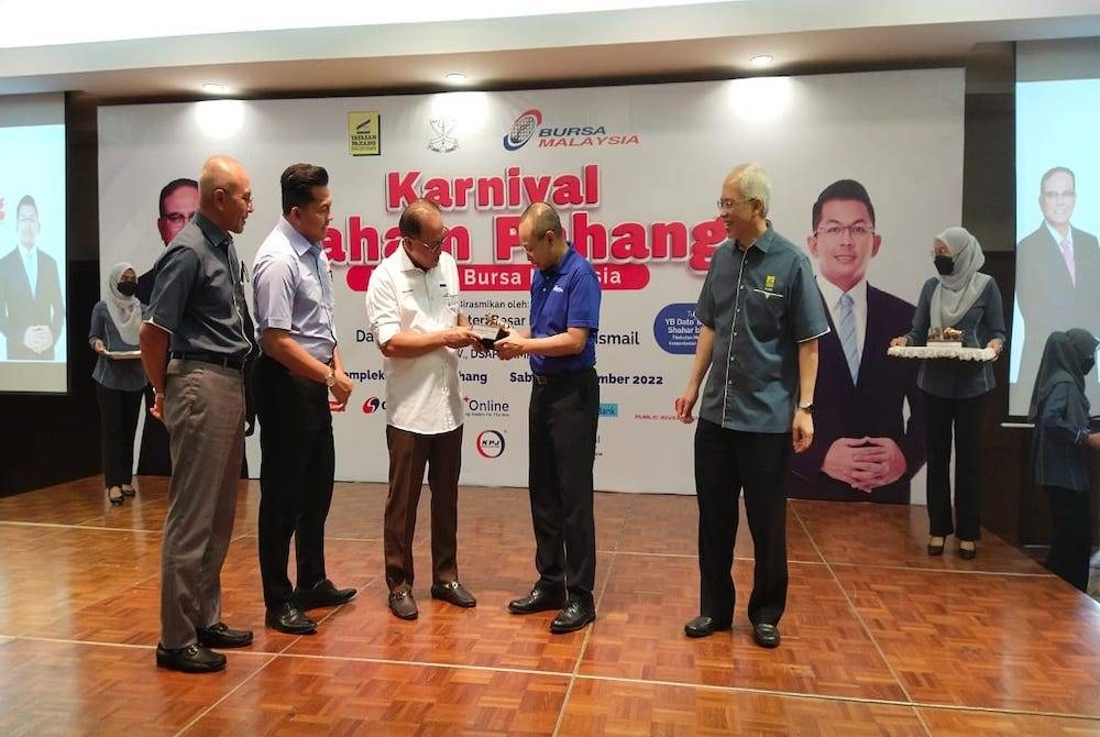 Pengerusi Bursa Malaysia,Tan Sri Abdul Wahid Omar (dua, kanan) menyampaikan cenderamata Menteri Besar Pahang, Datuk Seri Wan Rosdy Wan Ismail sempena Majlis Perasmian Karnival Saham Pahang Bersama Bursa Malaysia di Kompleks Yayasan Pahang, pada Sabtu.