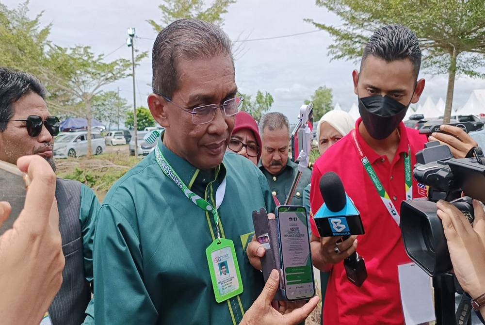 Takiyuddin menunjukkan surat jemputan ke Muktamar Tahunan Pas menerusi telefon pintar miliknya kepada pemberita pada Ahad.