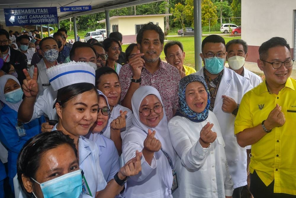 Khairy Jamaluddin bergambar bersama para petugas Hospital Simunjan ketika melawat hospital itu pada Isnin. - Foto Bernama