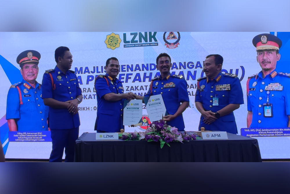 Aminurrahim (dua dari kanan) bersalaman dengan Zakaria (dua dari kiri) pada Majlis Menandatangani Note of Understanding (NOU) bagi pembangunan Civil Defence Auxilliary Action System (CDAS) di Menara Zakat, di Alor Setar, pada Selasa.