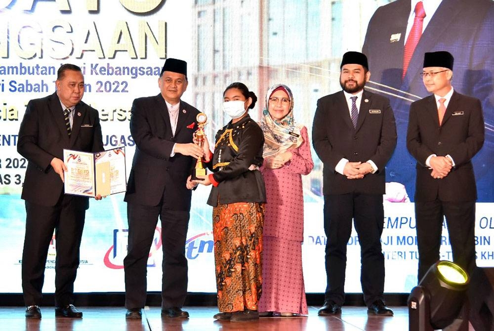 Mohd Arifin (dua dari kiri) menyampaikan hadiah kepada Floriana Mikayla sebagai johan Pertandingan Pidato Kebangsaan Peringkat Sabah bagi kategori sekolah rendah di Menara Kinabalu, Kota Kinabalu.