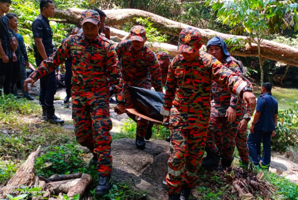 Anggota dari Balai Bomba dan Penyelamat Kampar yang tiba membantu membawa keluar mayat mangsa untuk diserahkan kepada pihak polis. - Foto Ihsan Bomba Perak