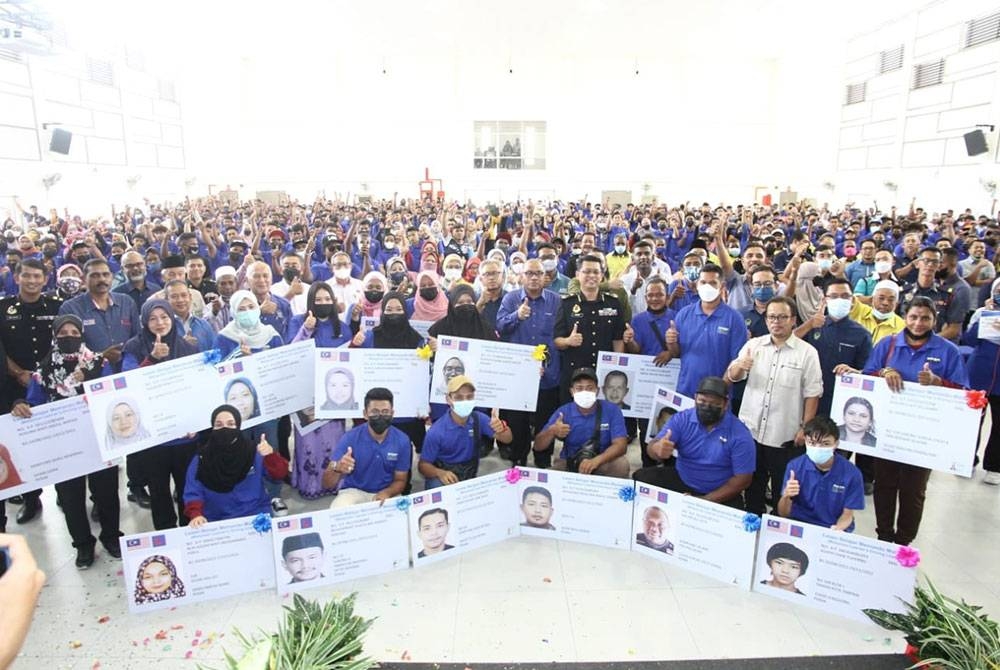 Mohd Zolkafly (berdiri, tujuh dari kanan) bersama sebahagian penerima lesen L pada Majlis Perasmian dan Penyerahan Lesen Motosikal Perak Sejahtera di Orang Asli One Stop Center, Bawong pada Selasa.