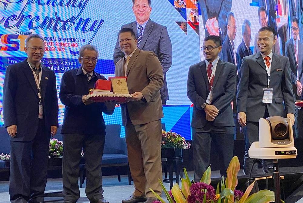 Razli (tengah) menyampaikan cenderamata kepada Presiden Persatuan Sains dan Teknologi Keadaan Pepejal Malaysia (MASS) Prof Dr Abdul Halim Shaari (dua dari kiri) pada Persidangan Serantau ke-31 Mengenai Keadaan Pepejal, Sains dan Teknologi (RCSSST 2022) di Kota Bharu pada Rabu.