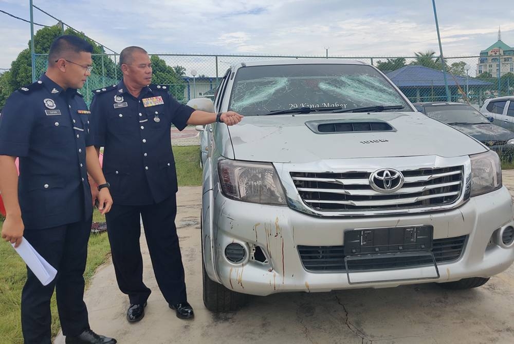 Ramli (kanan) menunjukkan kenderaan digunakan dalam pergaduhan dua kumpulan di Taman Melor Kampung Kuantan di sini pada Ahad.