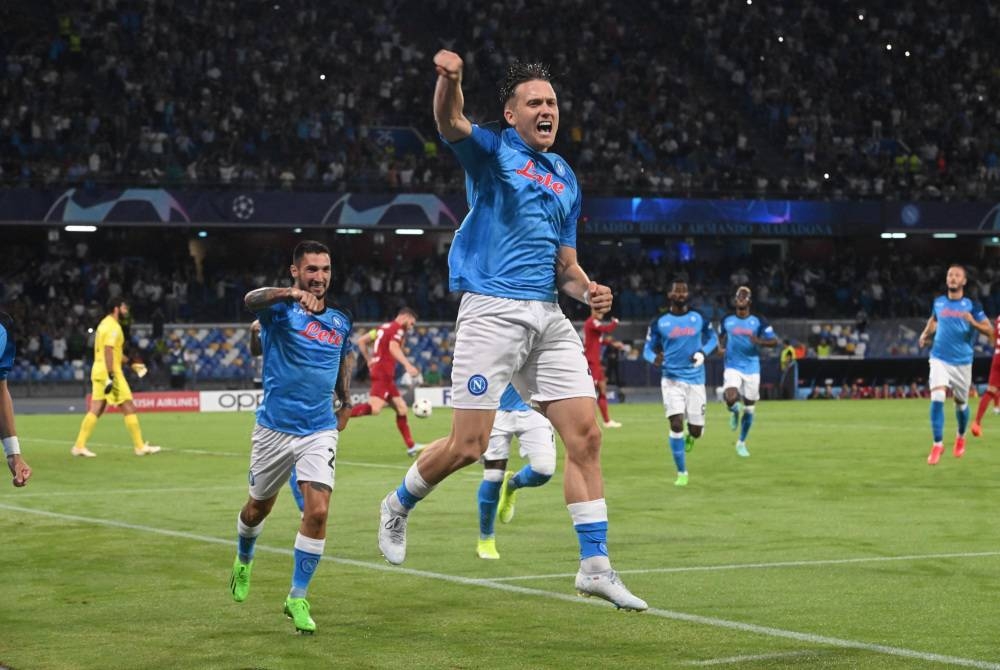 Pemain Napoli, Piotr Zielinsky (hadapan) melonjak tinggi ketika meraikan jaringannya ketika berdepan Liverpool pada aksi Liga Juara-Juara di Stadio Diego Armando Maradona pada Khamis. - Foto EPA