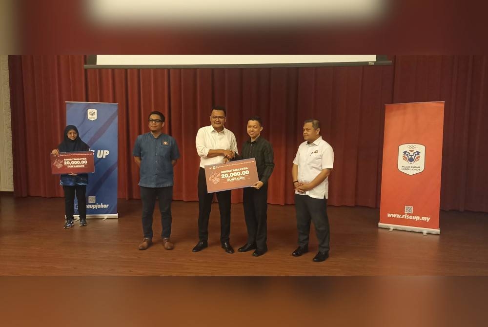 Mohd Hairi (dua dari kiri) menyerahkan peruntukkan subsidi pengelolaan Sukan Bangsa Johor kepada wakil-wakil DUN di Bangunan Sultan Ismail pada petang Rabu.