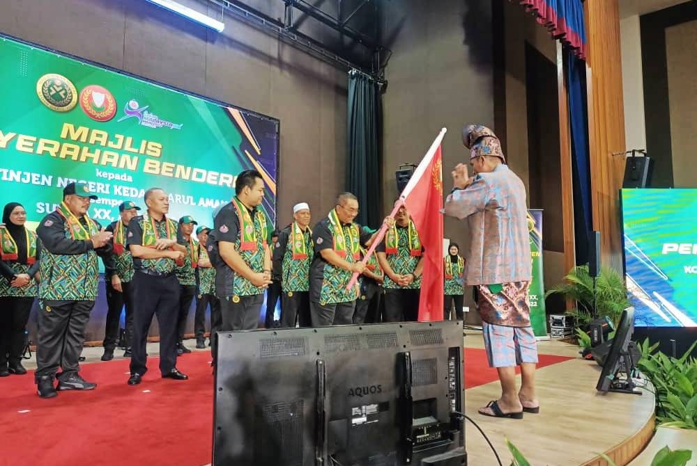 Muhammad Sanusi menerima bendera negeri Kedah untuk disampaikan kepada ketua kontinjen.