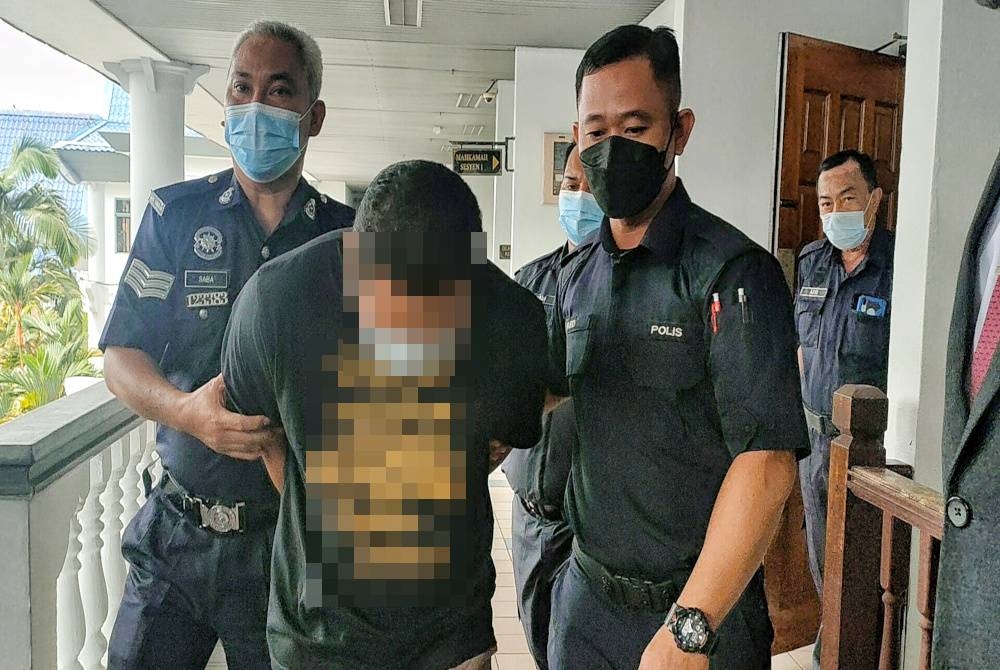 Tertuduh (tengah) ketika dibawa keluar dari Mahkamah Sesyen atas 12 pertuduhan seksual pada Khamis.