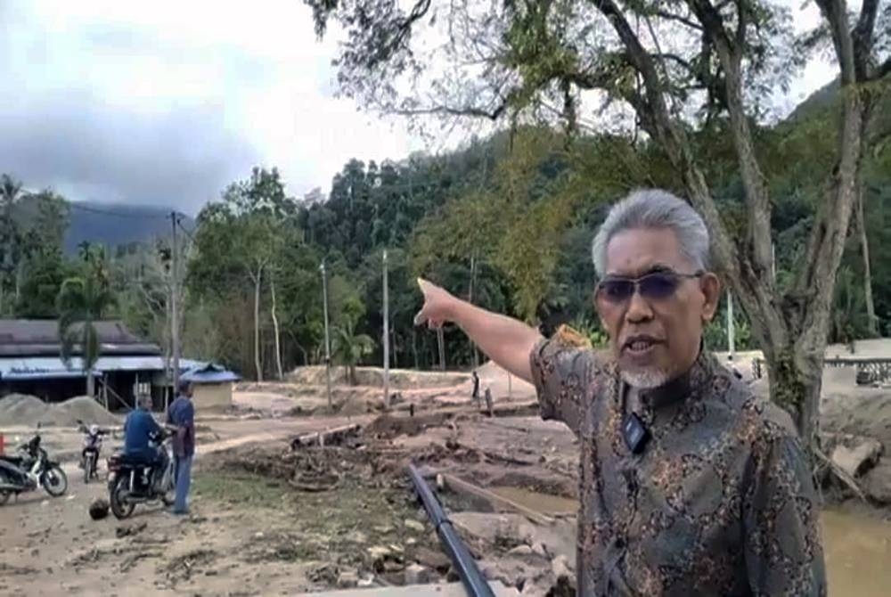 Dr Ismail menunjukkan kedudukan Gunung Inas dari Kampung Iboi
ketika meninjau keadaan banjir kilat di kampung tersebut pada Khamis.