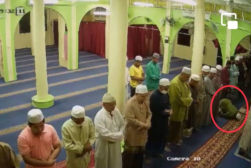 Mohd Radzi (dalam bulatan merah) rebah dalam keadaan bersujud ketika rakaat pertama solat Maghrib berjemaah di Masjid Mukim Kenor, Kuala Krai. - Foto Masjid Mukim Kenor