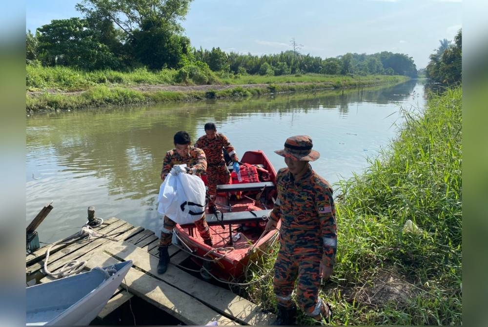 Anggota bomba membawa kepala mangsa yang ditemui terapung di sungai untuk diserahkan kepada pihak polis.