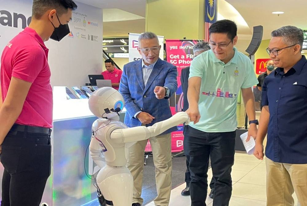 Zairil (dua dari kanan) berinteraksi dengan robot yang diberi nama Pepper ketika melancarkan rangkaian 5G di LTAPP pada Ahad.