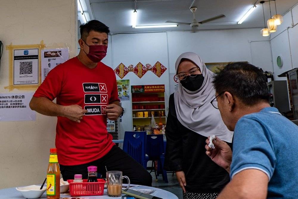 Amira Aisya (kanan) beramah mesra dengan penduduk setempat di sebuah kopitiam di Puteri Wangsa, Johor Bahru.