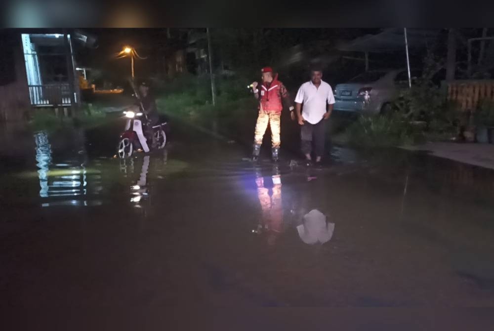 Anggota bomba melakukan pemantauan ketika air pasang berlaku di Kampung Nelayan Benut pada malam Ahad.