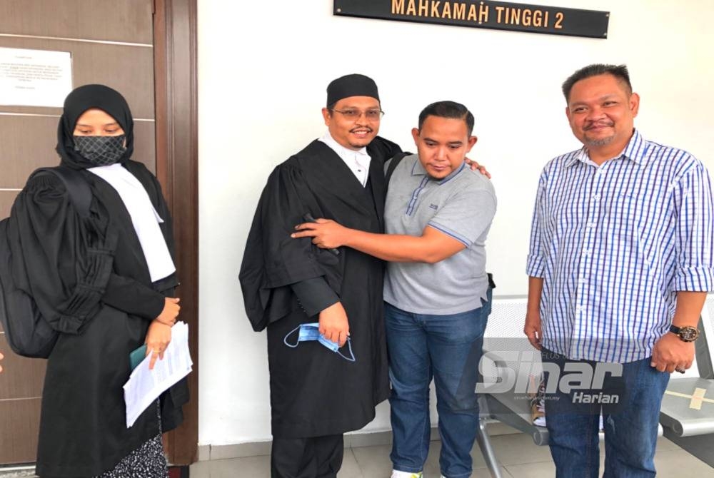 Muhammad Maliki (dua dari kanan) memeluk Shaharuddin selepas menang tuntutan ganti rugi RM330,000 di Mahkamah Tinggi Kota Bharu pada Isnin.