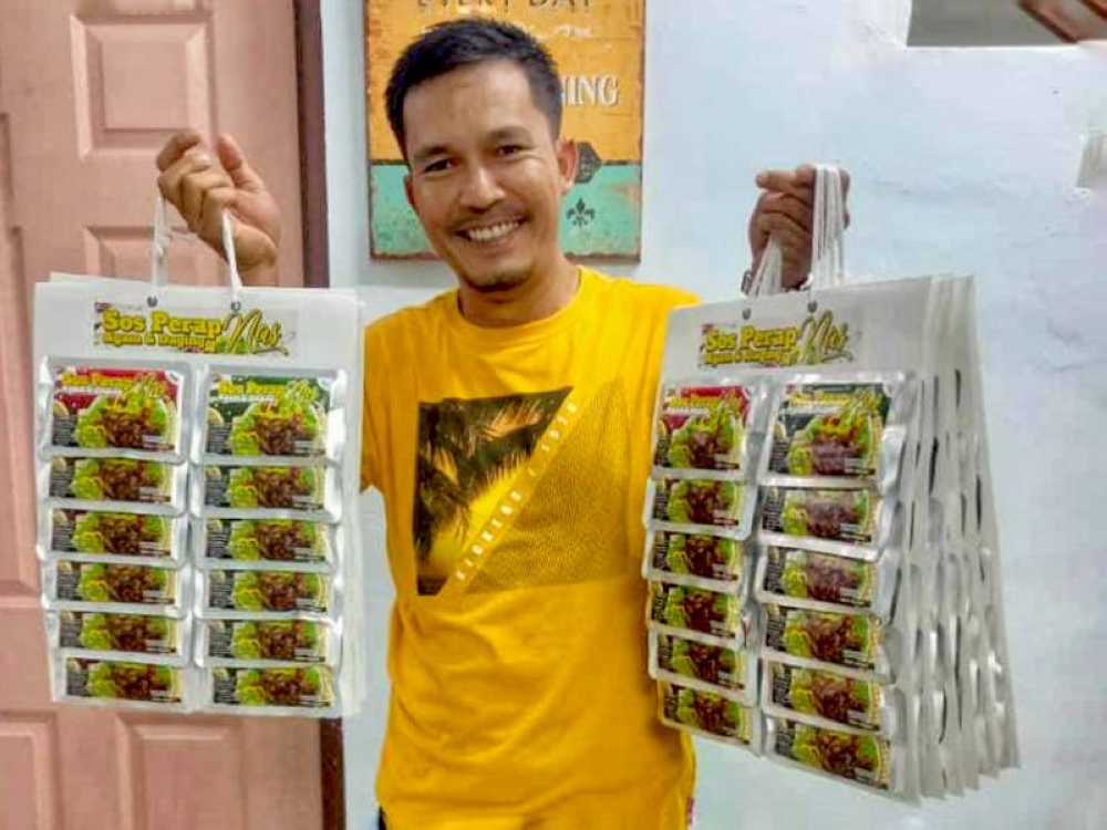 Shahrul Izuan bersama produk sos perap yang dihasilkan.