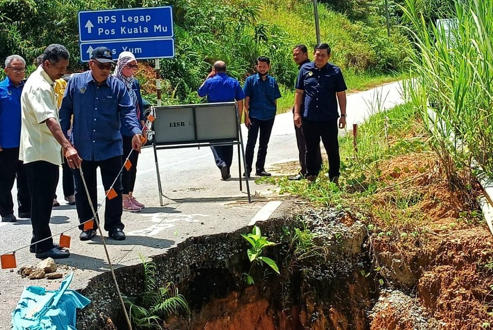 Mohd Zolkafly (dua dari kiri) meninjau keadaan cerun yang kritikal di laluan dari Kampung Bawong ke Rancangan Penempatan Semula (RPS) Pos Legap di sini pada Isnin.