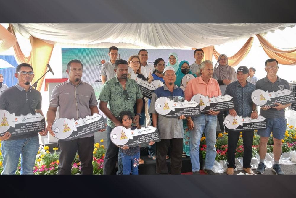 Amirudin (belakang, dua dari kiri) bergambar bersama penerima pada Majlis Penyerahan Kunci Rumah Kos Rendah Projek Taman Sungai Yu Indah pada Isnin.