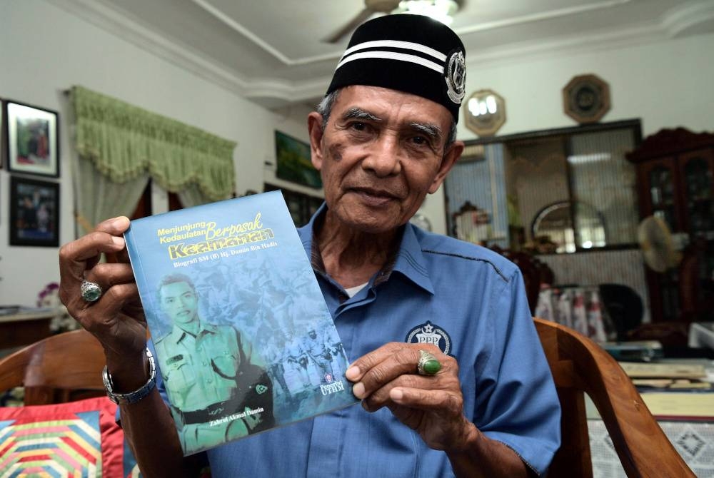 Sarjan Mejar (B) Damin Hadis, 77, menunjukkan buku &#039;Menjunjung Kedaulatan Berpasak Keamanan&#039; yang menceritakan kisah hidup dan pengalaman yang ditempuhnya ketika berkhidmat dalam PDRM semasa ditemui di rumahnya di Pekan Pekan Nanas, Pontian baru-baru ini. - Foto Bernama
Perjalanan kisah Damin telah dibukukan, hasil penulisan anaknya yang merupakan Pensyarah Kanan Pusat Pengajian Umum dan Kokurikulum, Universiti Tun Hussein Onn Malaysia (UTHM) Dr Zahrul Akmal yang berjudul ‘Menjunjung Kedaulatan Berpasak Keamanan: Biografi SM (B) Hj Damin Bin Hadis’ yang diterbitkan pada 20 Feb 2020.
--fotoBERNAMA (2022) HAK CIPTA TERPELIHARA