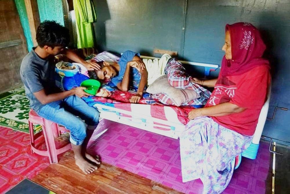 Mohd Shahruddin (kiri) sanggup berhenti kerja semata-mata mahu menjaga abangnya yang hilang upaya untuk bergerak selepas diserang penyakit kanser prostat di Kampung Kedai Lama, Rantau Panjang.