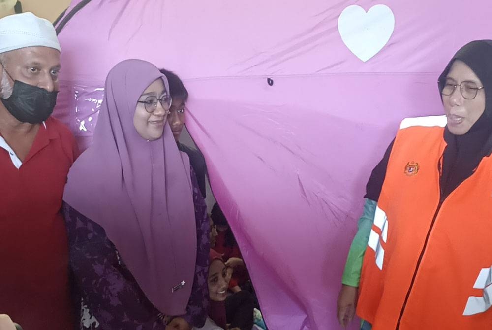 Siti Zailah (kanan) bertanya khabar Sahrudin (kiri) yang merupakan mangsa banjir ditempatkan di pusat pemindahan sementara (PPS) SMK Sri Gading Batu Pahat, pada Khamis.