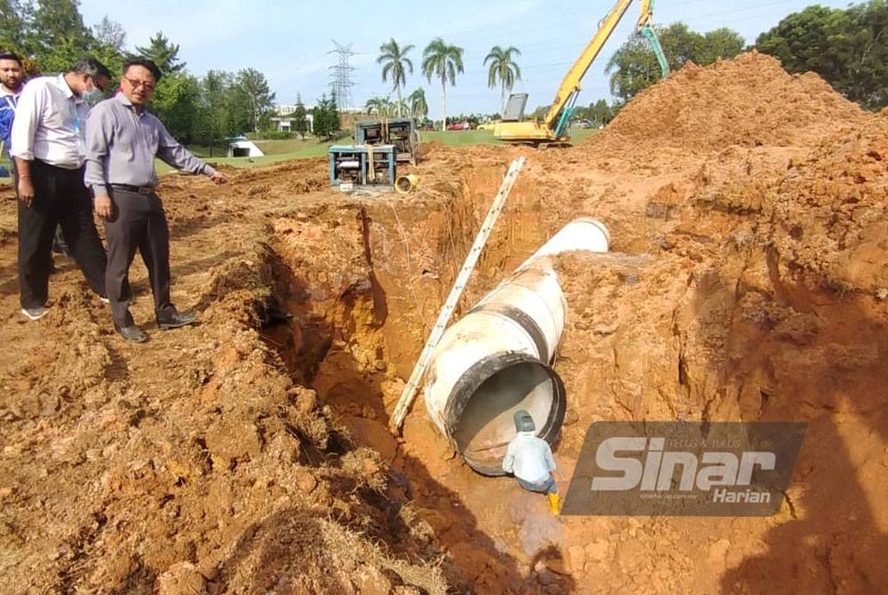 Saiful Zaini meninjau kerja-kerja pemasangan paip baharu yang dialihkan bagi mempercepatkan kerja-kerja penyelenggaraan paip bekalan air mentah utama pecah di MGCC di sini.