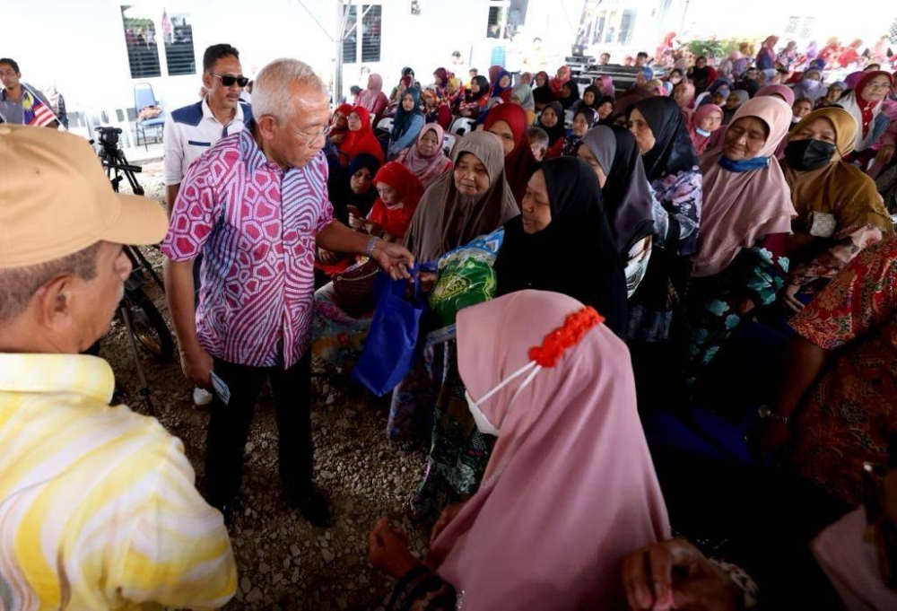 Mahdzir (kiri) beramah mesra dengan penduduk setempat yang hadir memeriahkan program Mesra Pengguna di pekarangan Pejabat Koperasi Kampung Padang Nyior Kedah Berhad pada Khamis.
