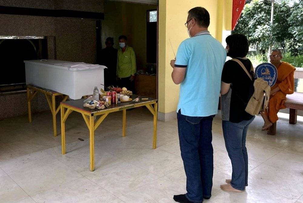 Chee Kong bersama isteri memberi penghormatan kepada anak lelaki mereka semasa upacara pembakaran di Kuil Hin Kong di Si Racha di wilayah Chonburi, Thailand. - Foto Bernama