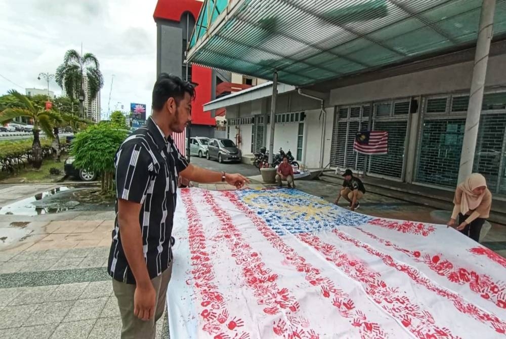 Pengerusi Kelab Putra Alor Setar, Muhammad Syafiq Othman memberi arahan kepada ahli Kelab Putra Alor Setar bagi menjayakan aktiviti menghasilkan Jalur Gemilang Mega sempena sambutan Hari Malaysia, pada Jumaat.