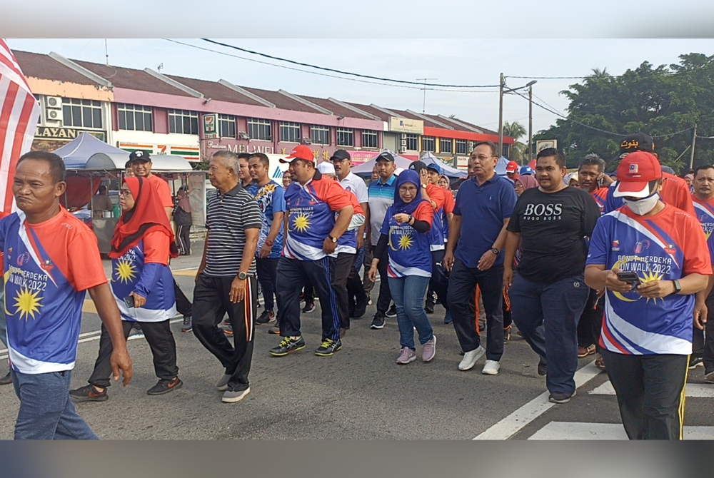 Hasni (tiga dari kanan) berjalan kaki pada Program Benut Fun Walk, Hari Tanpa Kenderaan di Pekan Benut pada Jumaat.