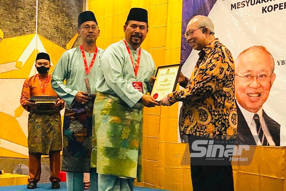 Tengku Razaleigh (kanan) menyampaikan sijil penghargaan kepada ahli Lembaga Koperasi KGMMB Bhd, Megat Pauzi Ibrahim (dua dari kanan) pada Jumaat.