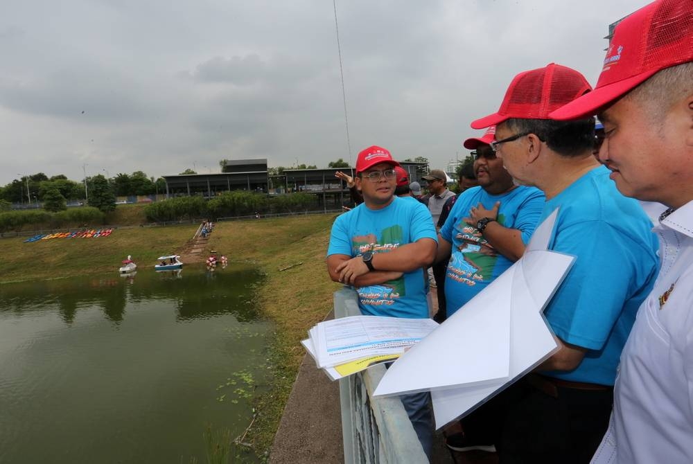 Amirudin (kiri) meninjau kolam takungan banjir Taman Eko Ara Damansara, pada Ahad.