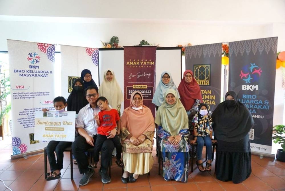 Asma Ahmad (dua, kanan) menyampaikan sumbangan kepada Noradilah Rani dan empat anaknya dalam program penyerahan sumbangan Isma kepada anak-anak yatim Covid-19 di pusat beli-belah Aeon Bandar Dato&#039; Onn, Johor Bahru, pada Sabtu