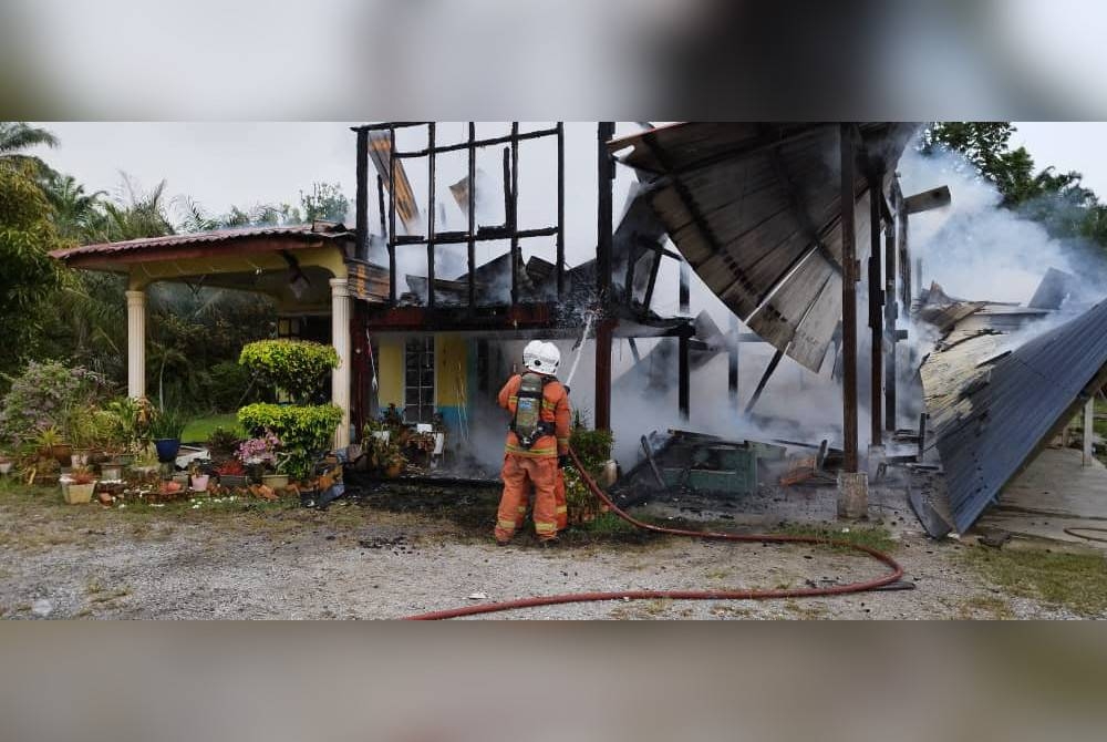 Anggota bomba melakukan kerja-kerja memadamkan kebakaran melibatkan sebuah rumah di Jalan Haji Mahsudi, Kampung Jenjarom pada Ahad.